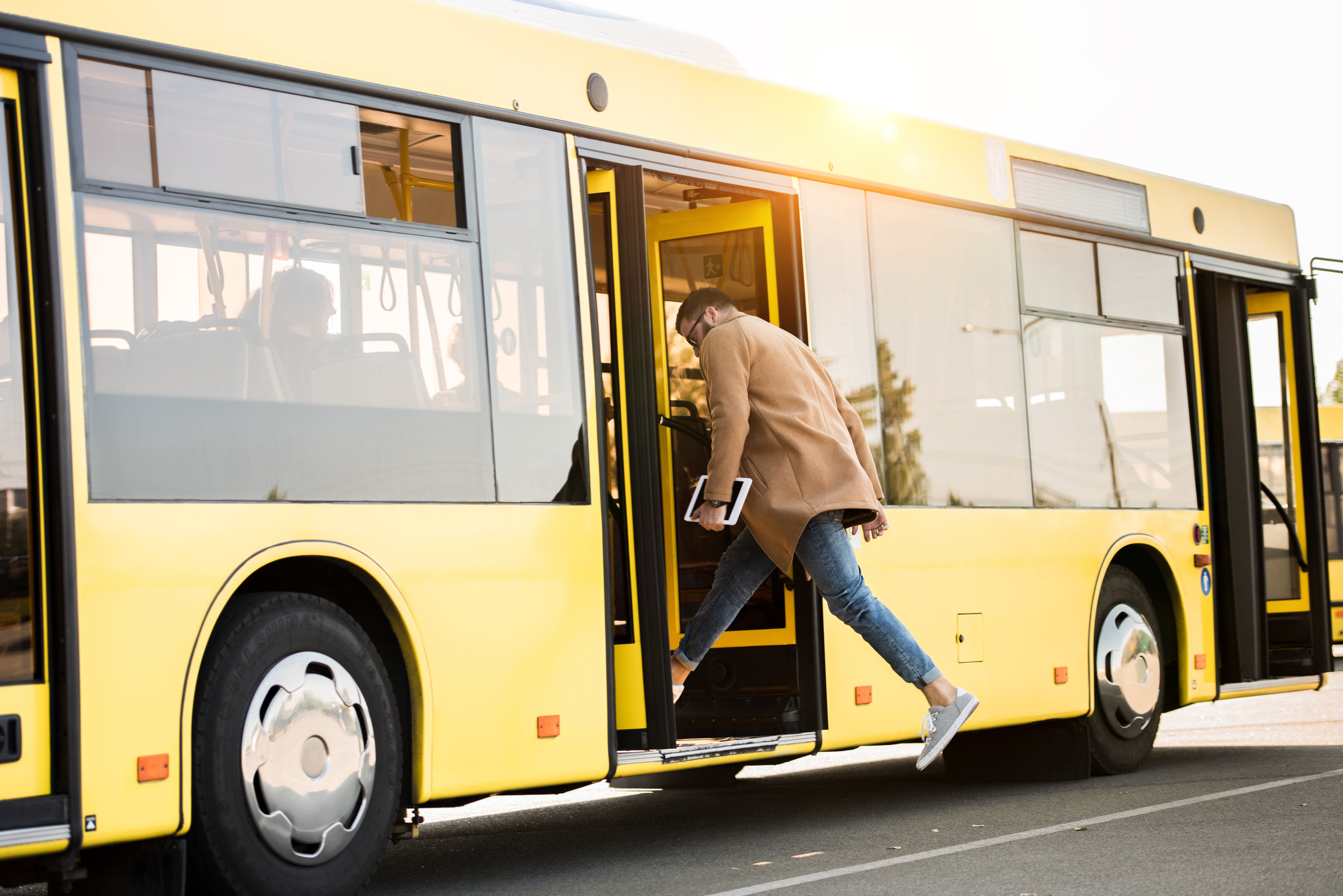 young man entering bus Public transportation vs riding a bike